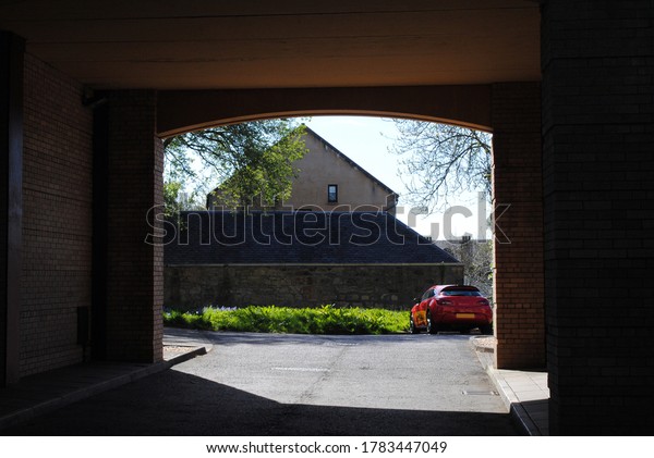 Arched Vehicle Entrance Beneath Building Leading to Car
Park 