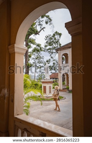 Arched window frames a courtyard statue and passing visitor, Lang Song Seminary, Gia Lai, Vietnam