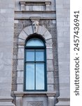 Arched window of the historic circa 1860 smooth cut stone Customs House at 130 Dalhousie Street in the old port area, Quebec City, Quebec, Canada