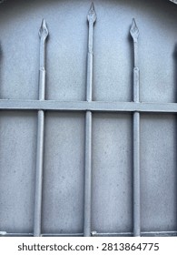 Arched window with iron bars and rough plaster wall texture
Close up of arched window with grey iron security bars set in rough textured plaster wall. Architectural detail background.