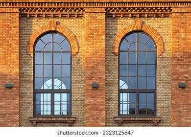 The arched windows of an old factory hall built of beautifully renovated bricks - Powered by Shutterstock