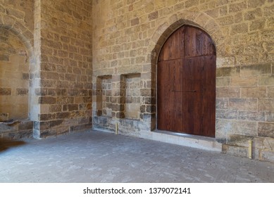 Arched wooden door and two embedded niches in stone bricks wall, Old Cairo, Egypt