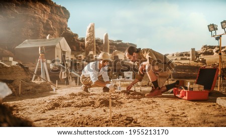 Archeological Digging Site: Two Great Archeologists Work on Excavation Site, Cleaning Cultural Artifacts with Brush and Tools. Discovery of Ancient Civilization Temple, Architecture, Fossil Remains