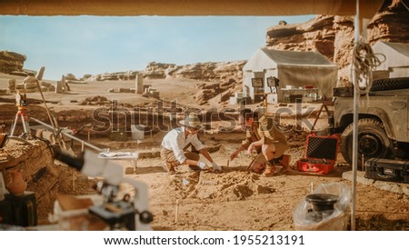 Archeological Digging Site: Two Great Archeologists Work on Excavation Site, Carefully Cleaning with Brushes and Tools Newly Discovered Ancient Civilization Cultural Artifacts, Fossil Remains