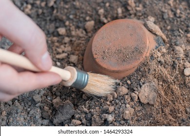archeology . Male hand holding brush. brush; excavation of rare pots and villages. tools for the excavation and culture of ancient settlements and caves. Elements of Culture BC