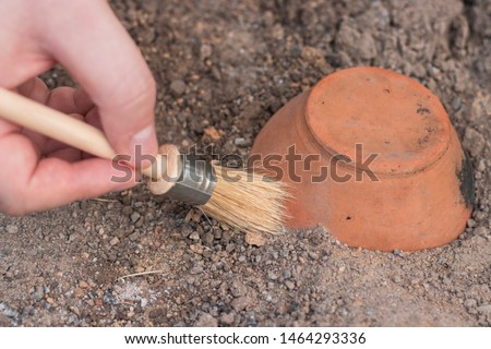 archeology . Male hand holding brush. brush; excavation of rare pots and villages. tools for the excavation and culture of ancient settlements and caves. Elements of Culture BC