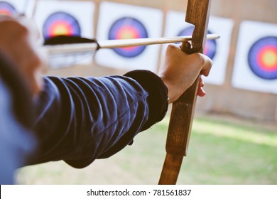 Archer holds his bow aiming at a target