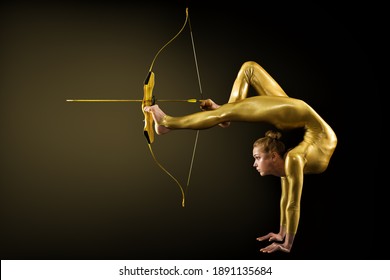 Archer Shooting by Legs with Gold Bow and Arrow. Flexible Gymnast aiming Target standing on Hand upside down. Goal Achievement Concept, Studio shot over Black background - Shutterstock ID 1891135684