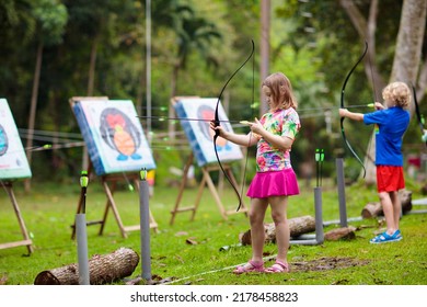 Archery For Child. Little Girl With Bow And Arrow. Kids Shoot On Tropical Island. Target On Outdoor Shooting Range. Archer Club For Young Children. Healthy Summer Activity.