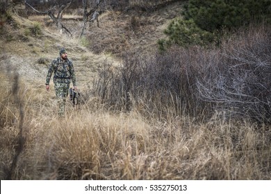 archery hunter hiking through the woods stalking his  - Powered by Shutterstock