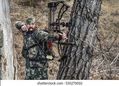 archery hunter with his bow drawn back ready for a shot - Powered by Shutterstock