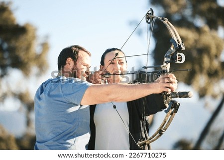 Archery, shooting range and sports training to aim with a woman and man outdoor for target practice. Archer and athlete person with focus on field for competition or game to shoot arrow for action