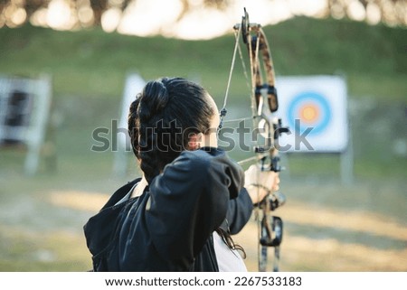 Archery, shooting range and target for sports training with a woman outdoor for bow practice. Archer athlete person with focus on field for competition or game to aim arrow for action and bullseye