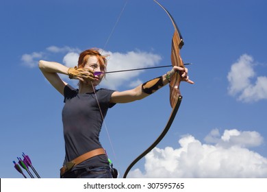 Archery woman bends bow archer target narrow in the summer field