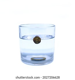 Archimedes' principle experiment. Cup with a cork floating in the water and submerged coin