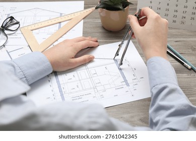 Architect with compass working on project at wooden table, closeup - Powered by Shutterstock - Get 15% off with code: PIKWIZARD15