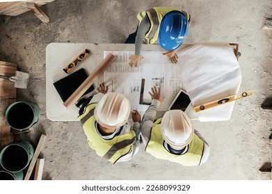 Architect, construction and blueprint with an engineer and designer team working on a building site from above. Meeting, planning and architecture with a design group in collaboration on a project - Powered by Shutterstock