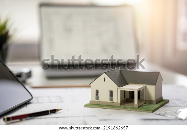 Architect Design Concept,\
House model on Buleprint construction drawing and drawing equipment\
stationary