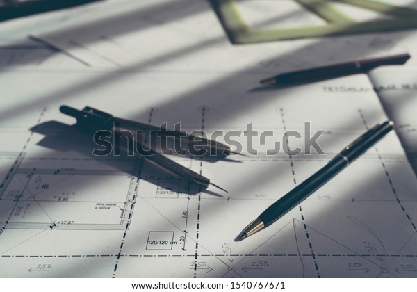 Architect design.\
Sketch, plans blueprints. Pencil, dividers, ruler. Sunlight on the\
blueprint. Architecture\
concept.