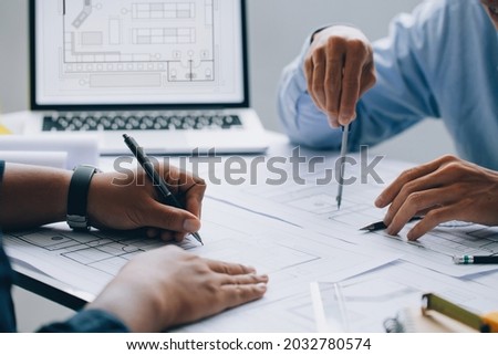 architect drawing on a blueprint on architectural project at the construction site at office desk in the office.Architectural and engineering concept.