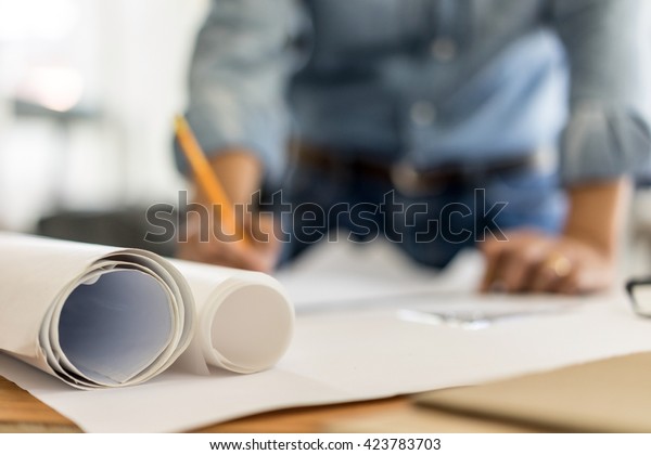 architect drawing on blueprint architectural\
concept, soft focus