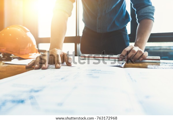 architect drawing on blueprint architectural\
concept, soft focus