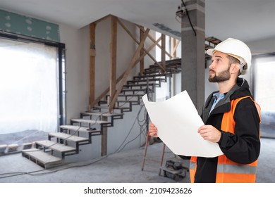 An architect with drawings in his hands. Man supervises construction work. Foreman in house under construction. A construction engineer in a hard hat and an orange vest. Builder with drawings. - Shutterstock ID 2109423626
