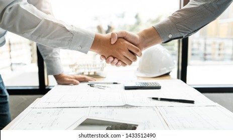 Architect and engineer construction workers shaking hands while working for teamwork and cooperation concept after finish an agreement in the office construction site, success collaboration concept 