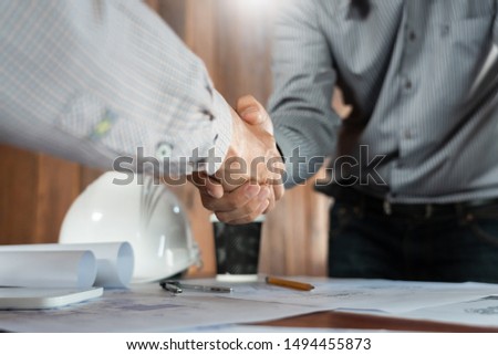 Architect and engineer construction workers shaking hands while working for teamwork and cooperation concept after finish an agreement in the office construction site, success collaboration concept 