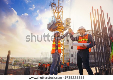 Architect and engineer construction workers shaking hands while working at outdoors construction site. Building construction collaboration concept