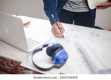 Architect engineer contractor design working drawing sketch plan blueprint. Concept architects, engineer holding pen pointing equipment architects On the desk. Selective Focus