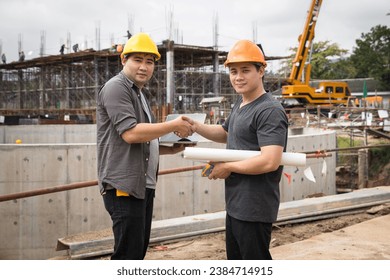 Architect and engineer or contractor shaking hands on construction house. Builders greeting each other with handshake on construction site. Success collaboration concept.