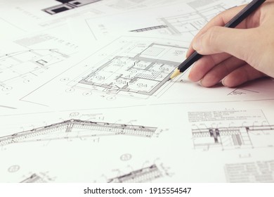 An architect engineer creates a working drawing sketch for building a house building. Architectural design projects concept. Engineering and architecture drawings - Shutterstock ID 1915554547