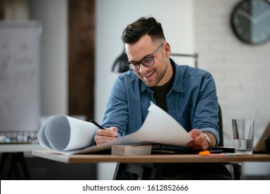 
Architect Engineer Design Working Planning Concept.
Portrait of a smiling young businessman working on blueprints at the office. - Shutterstock ID 1612852666