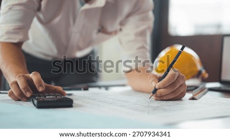 architect, engineer, engineering, architecture, design, plan, plans, construction, An engineer reviews construction blueprints while making calculations and notes on the design.