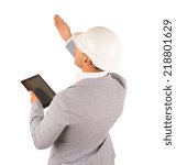 Architect or engineer giving instructions standing with his back to the camera holding a tablet with a blank screen and raising his hand, isolated on white