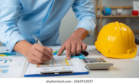 Architect or engineer sitting at desk in office, Cost calculation, Construction planning, structural calculation, Project construction cost planning and calculation, Project presentation plan. - Powered by Shutterstock