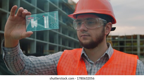 Architect or Engineer using smartphone transparent hologram digital display applicatiion in front of building under construction. Technology, people.
