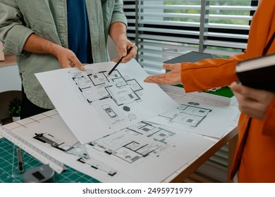 An architect and engineer work as a team, an engineer is discussing with coworker about detail of house model compare with blueprint to make sure it's exactly the same - Powered by Shutterstock