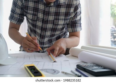 Architect or engineer working in office with blueprints,engineer inspection in workplace for architectural plan,sketching a construction project ,selective focus,Business construction concept.
