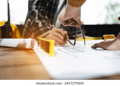 architect or engineer working on table use drawing tool on the paper plan for business architectural project.