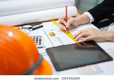 Architect or engineer working project accounting with graph with tools in office, Construction account concept.  