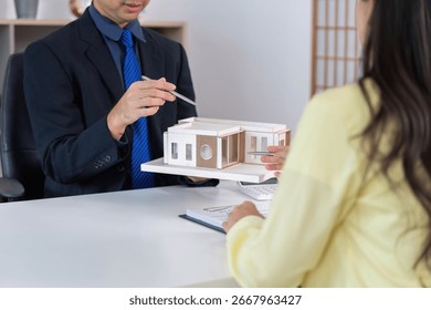 Architect explaining house model to client during meeting