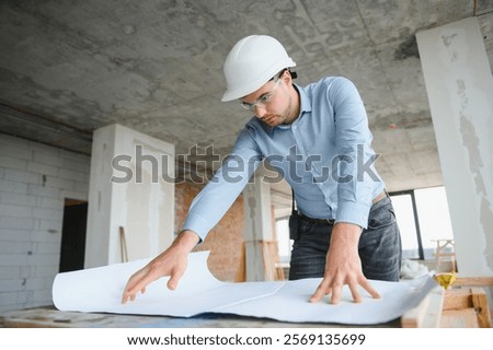 Architect in hard hat with draft.