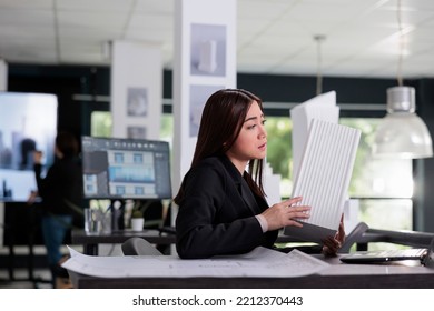 Architect Holding Building 3d Printed Model, Discussing Blueprints On Videocall In Architecture Office. Asian Employee Talking About Architectural Design On Online Meeting In Coworking Space