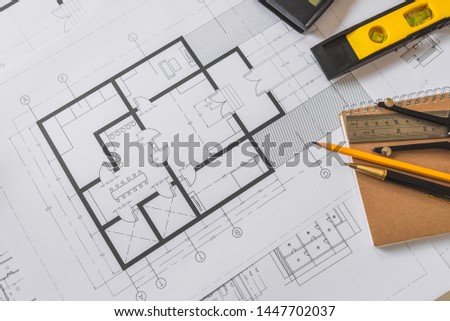 Architect house plan roled -up plans on the table, high angle view and engineer object.