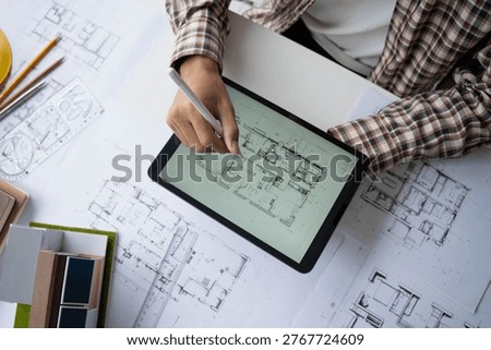 Architect Interior Design drawing checking home blueprint on tablet.
