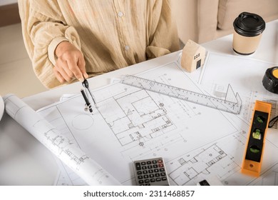 Architect interior design drawing with divider compass on house plan blueprint paper for editing on table desk at architecture office, Engineer sketching construction, Architectural project workplace - Powered by Shutterstock