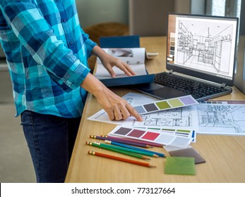 Architect (interior designer) working with drawing,  material sample & laptop computer in office / Business of Real estate, home decoration & renovation concept