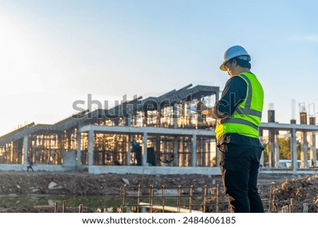 Architect man checking about the building plan and see how the construction progressive at the construction site